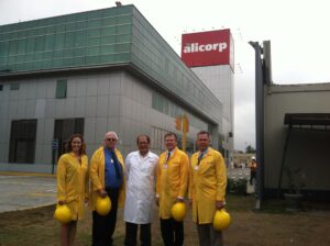 five people wearing lab coats stand in front of a commercial building in Peru. 