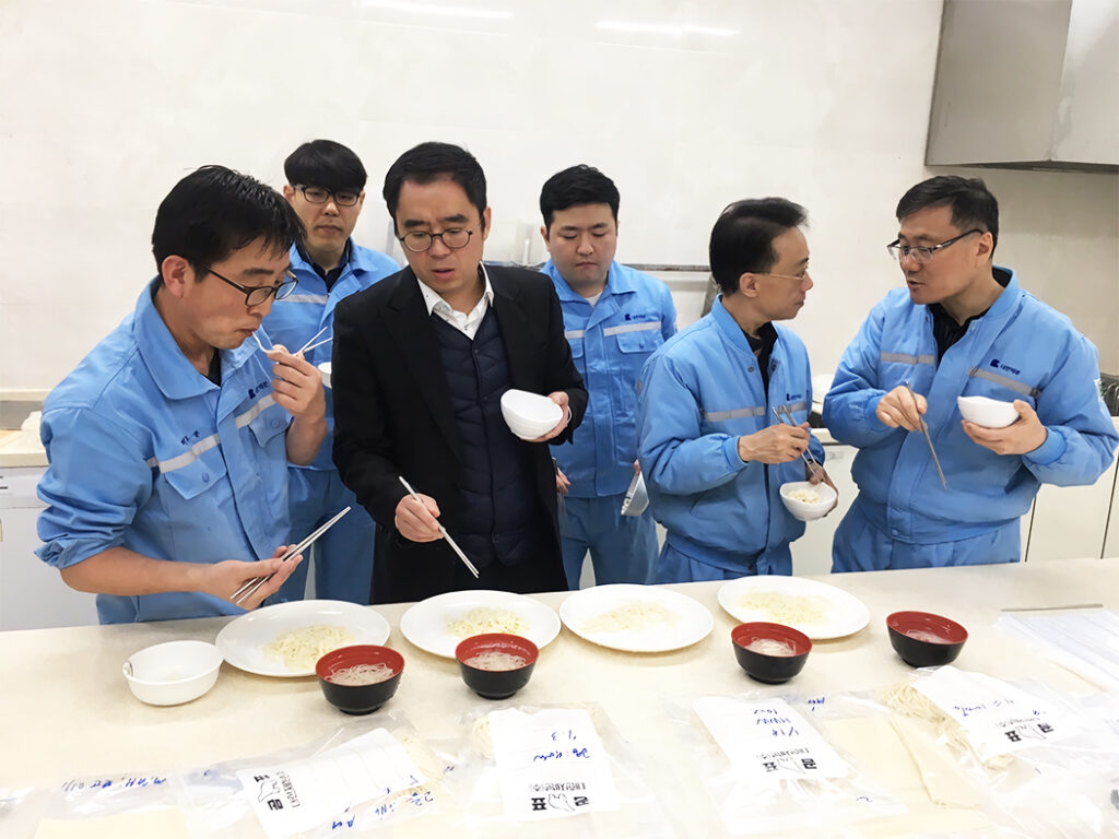 Group of people evaluate different noodles for quality. 