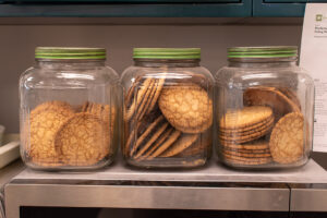 three clear glass jars of cookies in a row