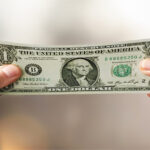 Hands stretching a dollar bill